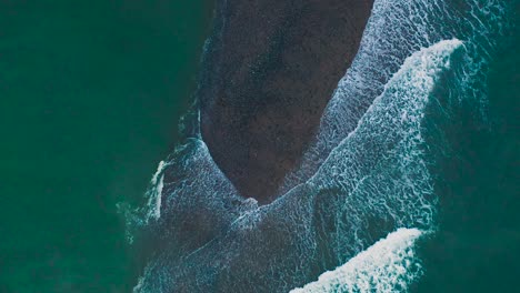 waves crashing over the beach during sunset