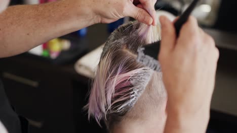 rear view woman having her hair styled by a hairdresser