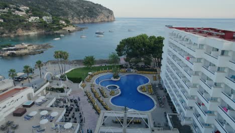 aerial establishing shot between luxury resort of bay filled with boats