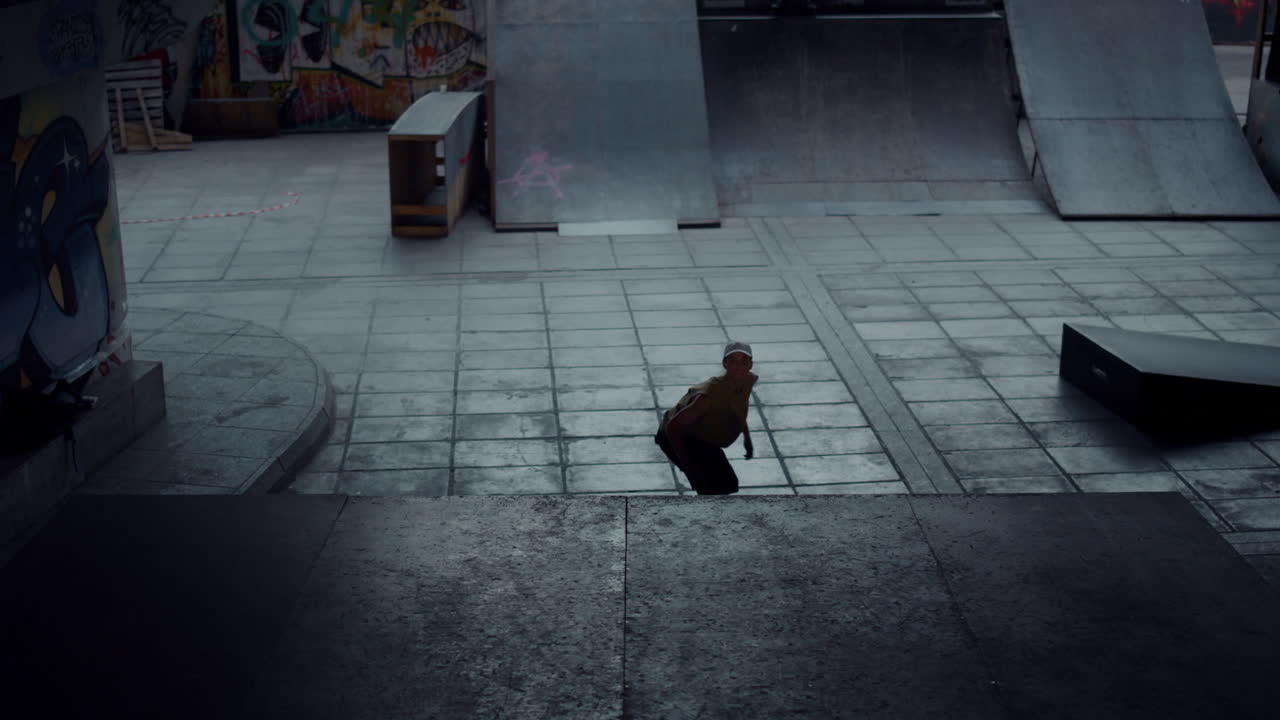 Sporty athlete preparing skateboard competition on ramp at urban skate park.