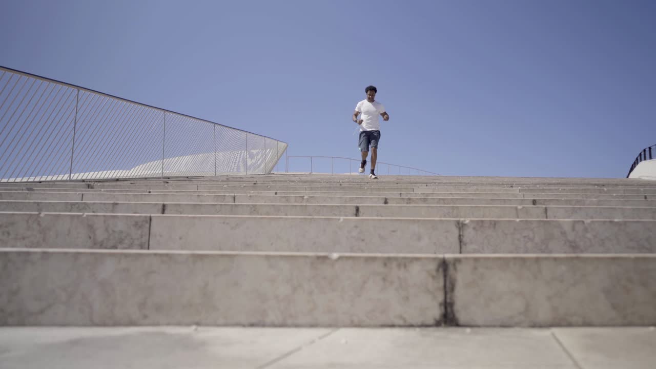 un joven deportivo sonriente corriendo por las escaleras.