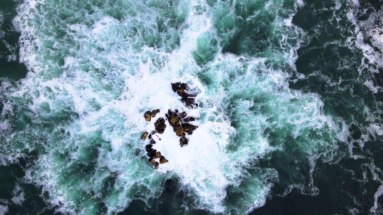 antena: el dron se eleva desde la roca en el océano, el incesante golpeteo de las olas