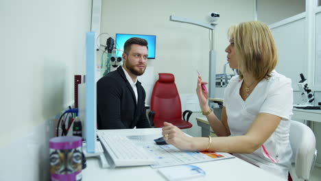 ophthalmologist and a patient. doctor consulting a male patient in eyesight center. handsome man listens to a specialist in clinic.