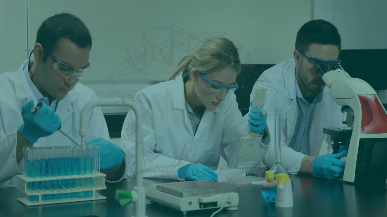Técnico de la izquierda pipeteando reactivo azul, iniciando la mezcla en el centro de investigación desde un matraz, mientras el de la derecha observa diapositivas.