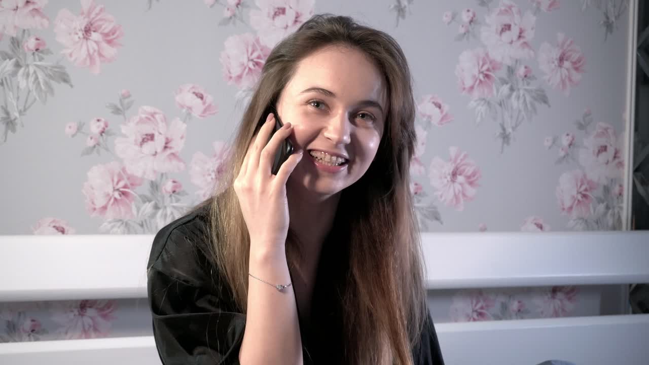 The girl works on the computer, lying in the bed.