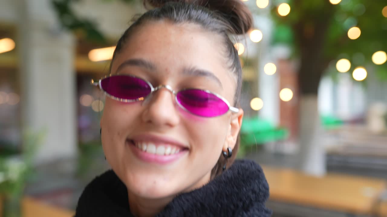 joven feliz con gafas de sol rosas