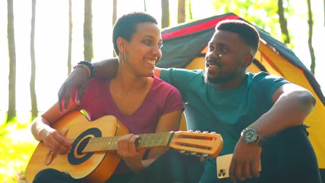 pareja latina hispana enamorada juntos en un gran día soleado en el parque con guitarra y tienda