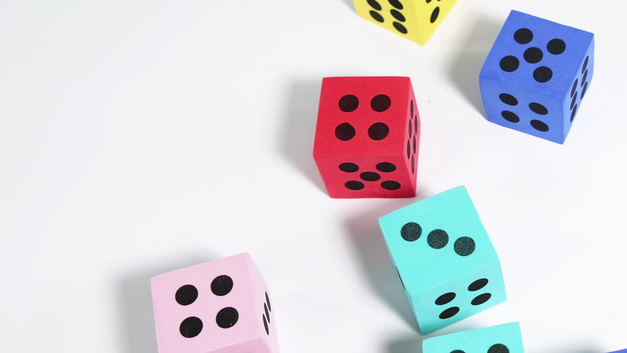 A collection of colorful dice falls and scatters across a white background, showcasing dynamic motion and variety.