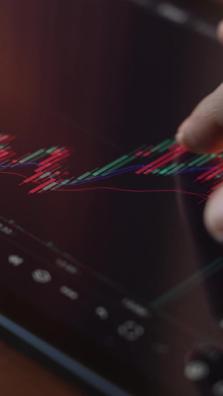 Trader che analizza i grafici del mercato azionario su un iPad tramite una piattaforma di intermediazione.