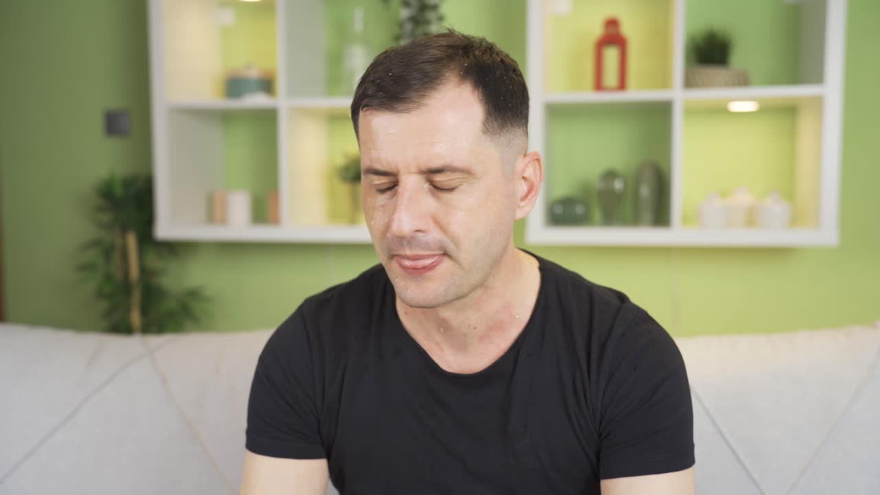 Worried and anxious man having panic attack is sweating.
