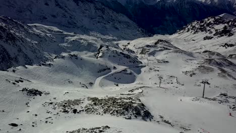 view of cable car funitels scattered across barren snowy landscape in val thorens, french alps - aerial fly over shot