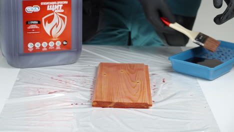 applying wood stain with protective gear