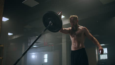 training of the boxer striking technique. push the bar with one hand. build-up of force blows for the fighter. training a sporty man.