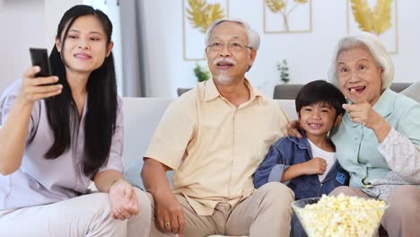 a family of four watches tv on a cozy couch, sharing popcorn and laughter in a bright living room