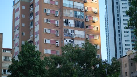 low angle shot of an apartment building in tel aviv with shattered windows and visible impact damage after an iranian missile strike