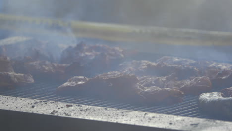 carne cocinada en una gran barbacoa con humo