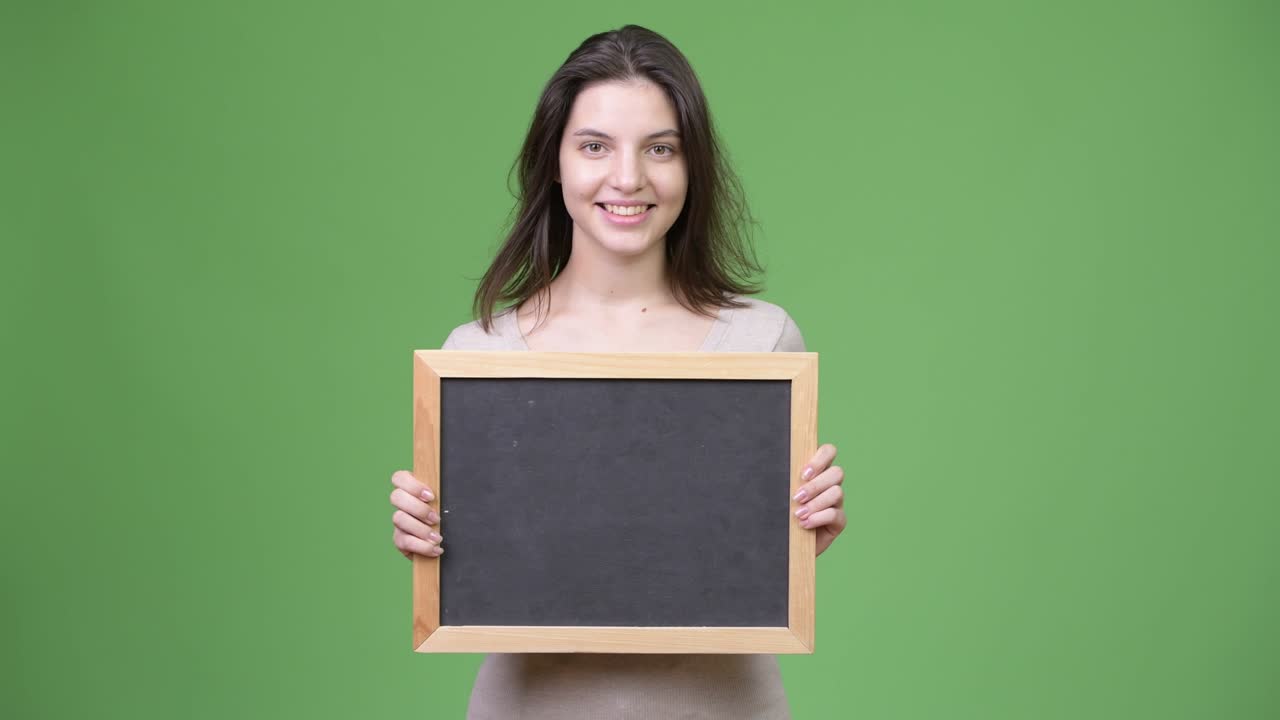 Young happy beautiful woman holding blackboard