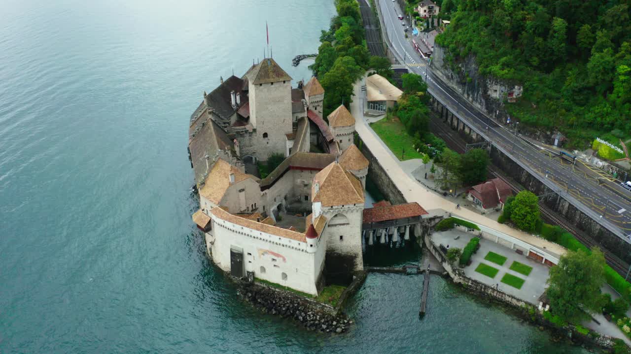drone camera is moving from behind the castle, and behind the castle is the name 'musee fort de chillon' HOLLYWOOD shot in Chillon castle Switzerland