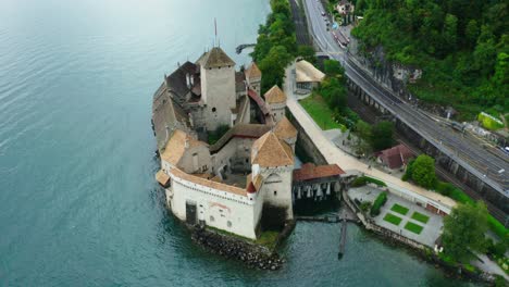 la cámara del avión no tripulado se mueve desde detrás del castillo, y detrás del castillo está el nombre 'musee fort de chillon' hollywood filmado en el castillo de chillon suiza