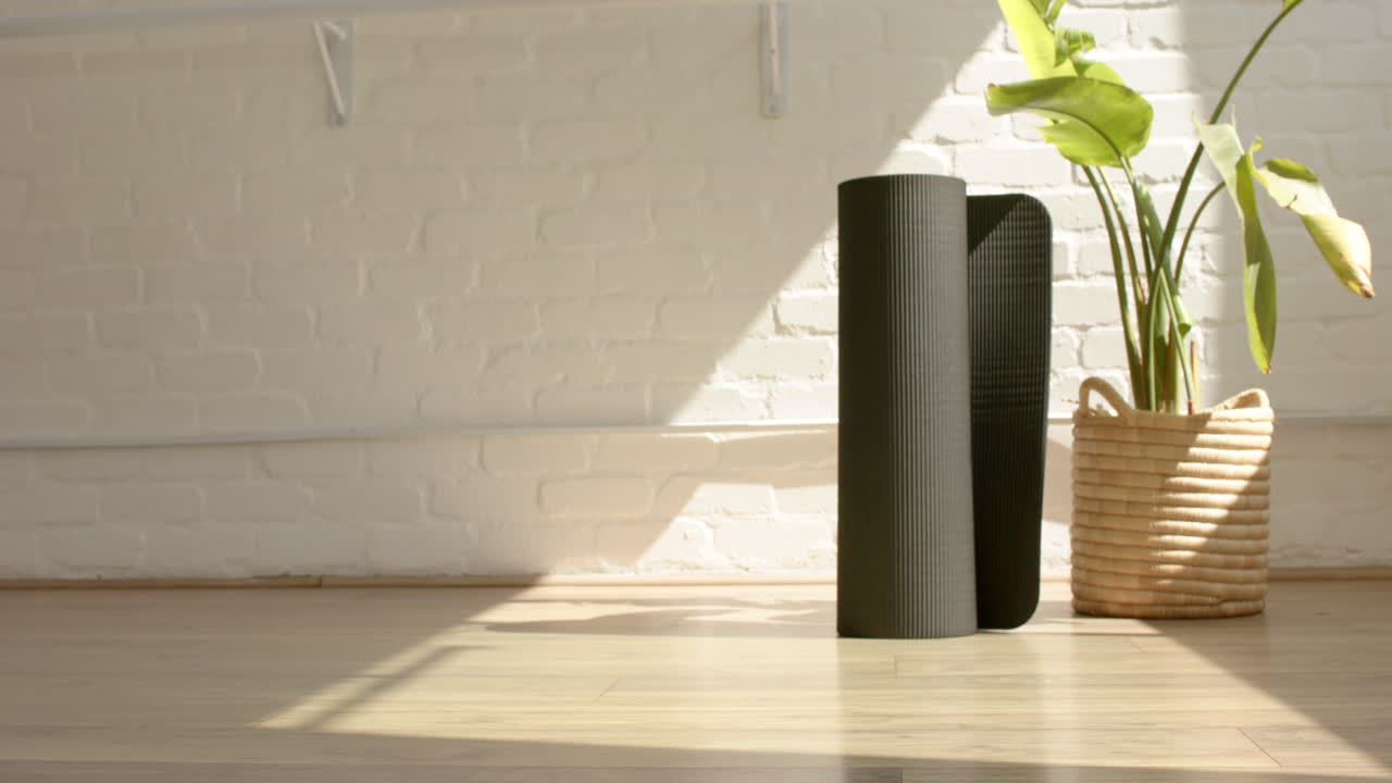 창문을 통해 나무 바닥에 굴러 요가 매트에 빛