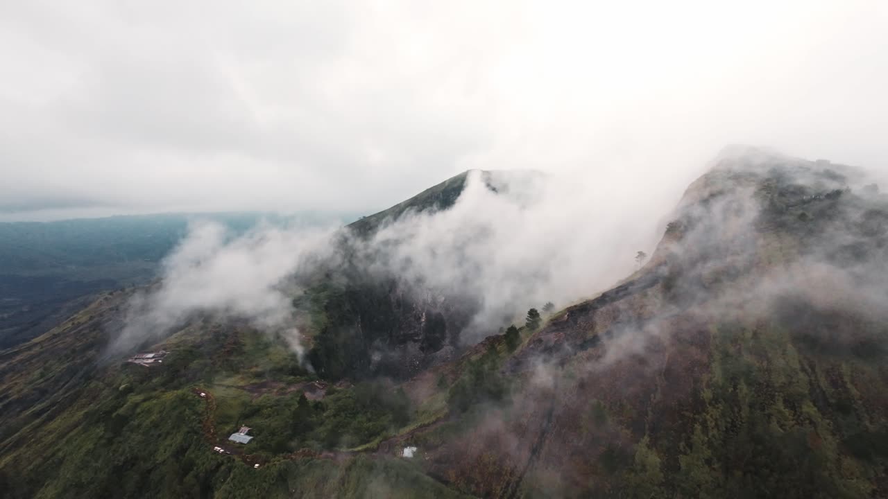 nubes blancas cubriendo el cráter del volcán batur en la isla de bali, vista aérea