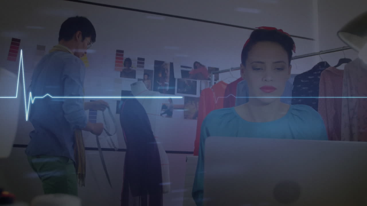animación de un monitor de ritmo cardíaco brillante, sobre una mujer que usa una computadora portátil en una oficina creativa