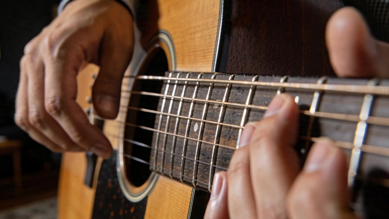Pizzicata con la mano destra, il chitarrista passa alla melodia su chitarra acustica a casa con polsino nero.