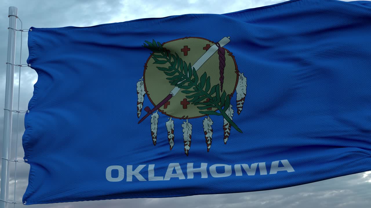 Flag of Oklahoma waving in the wind against deep beautiful clouds sky