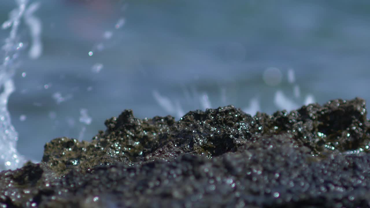 바다 근처의 바위와 물이 슬로우 모션으로 부서진다