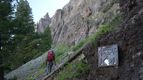 vrouwelijke klimmer op via ferrata-route in telluride colorado usa langs cimbers onder bord, achteraanzicht, slow motion