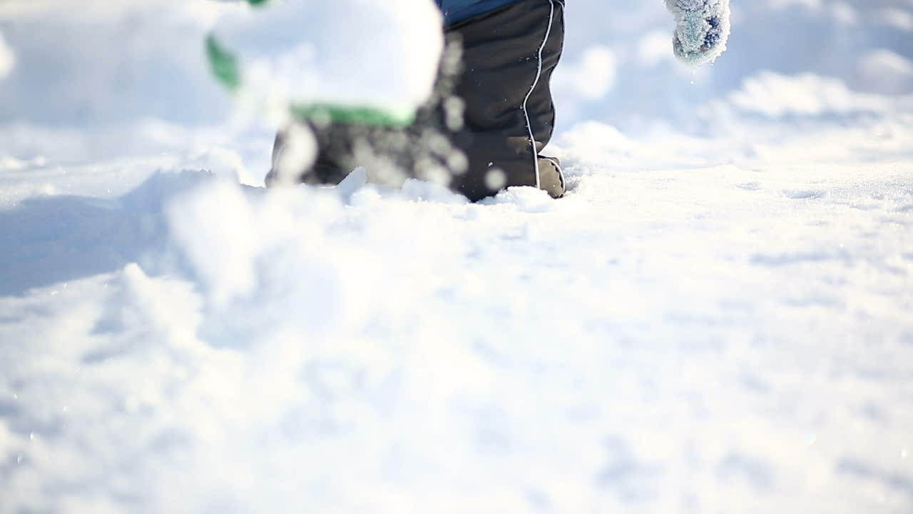 Little boy in winter day. Boy walking and having fun on a windy winter day