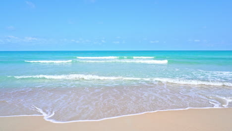 Waves-from-a-turquoise-ocean-wash-up-on-a-golden-beach