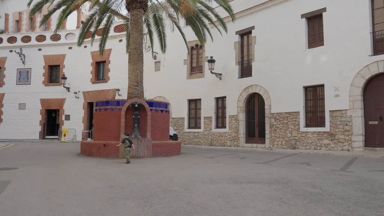 Toddler runs towards old fountain in ancient city
