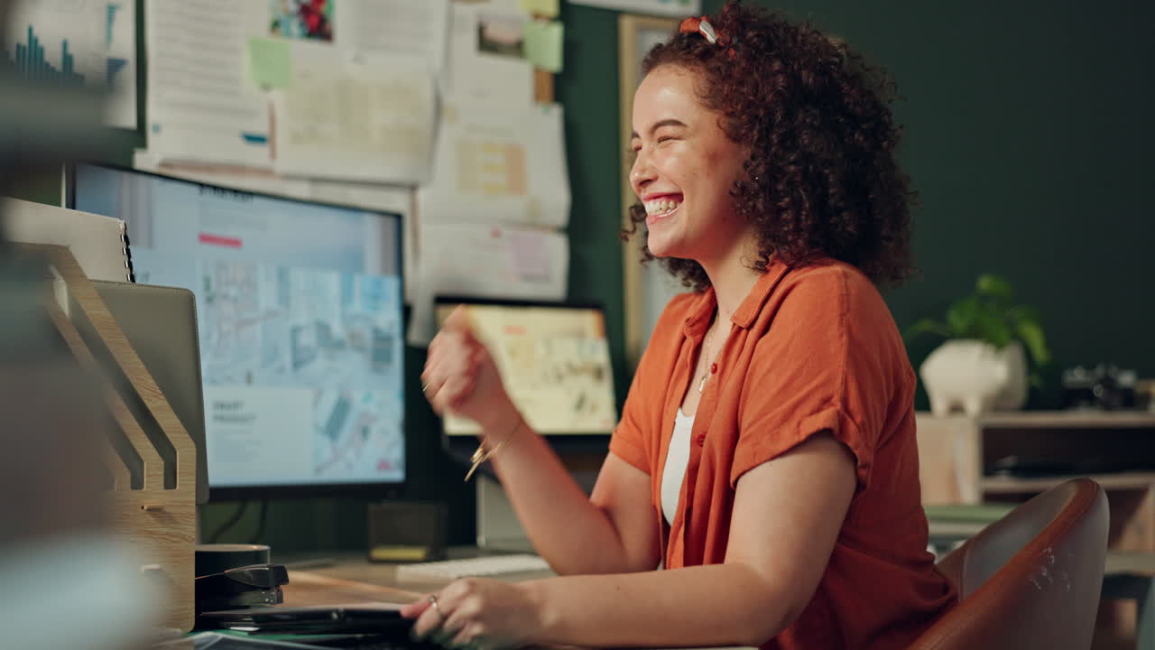 Excited woman celebrating success at her desk
