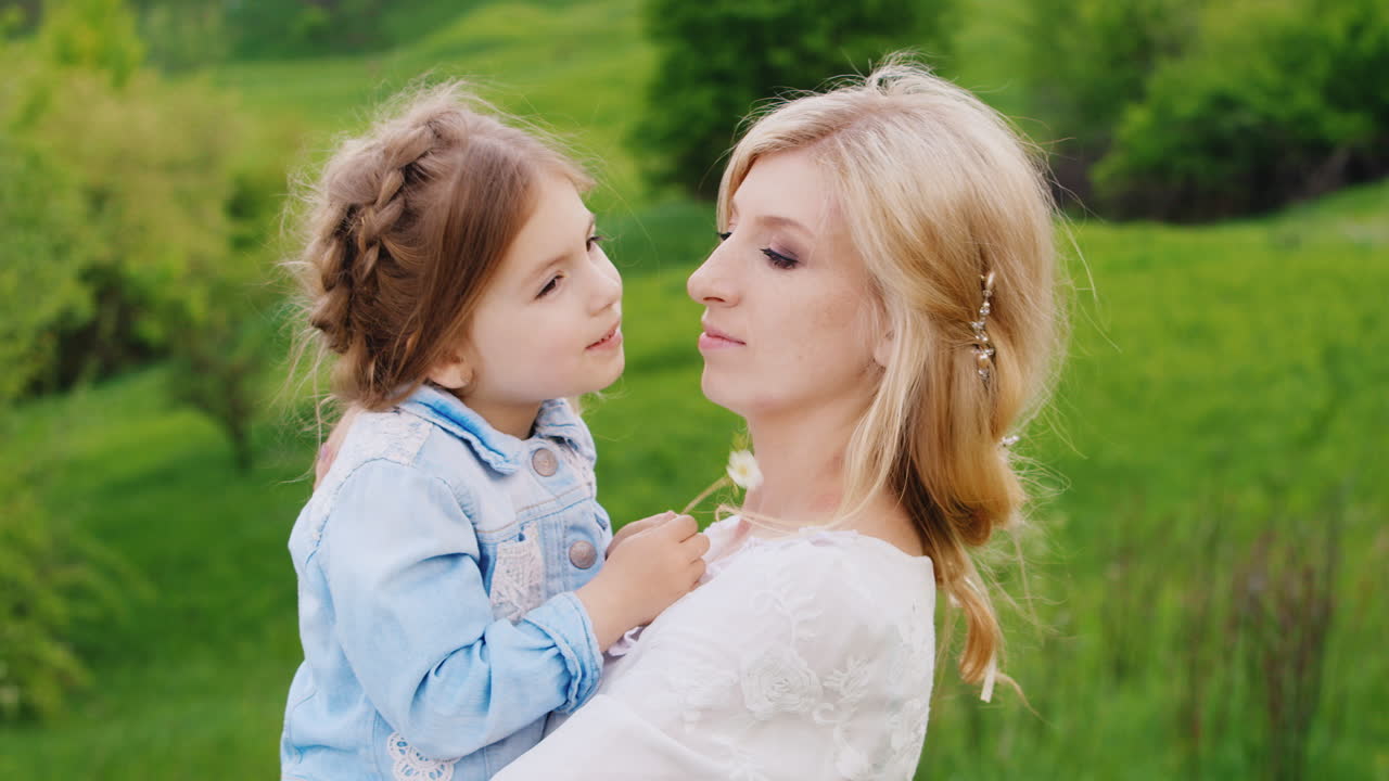 그녀의 팔을 잡고 부드럽게 그녀의 작은 딸을 포옹 생각에 잠겨있는 젊은 여자의 초상화