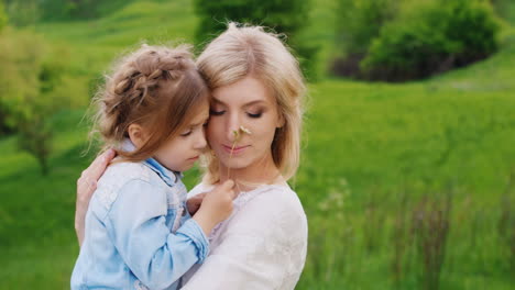 Portrait-Of-A-Pensive-Young-Woman-Who-Holds-Her-Arms-And-Gently-Embraces-Her-Little-Daughter