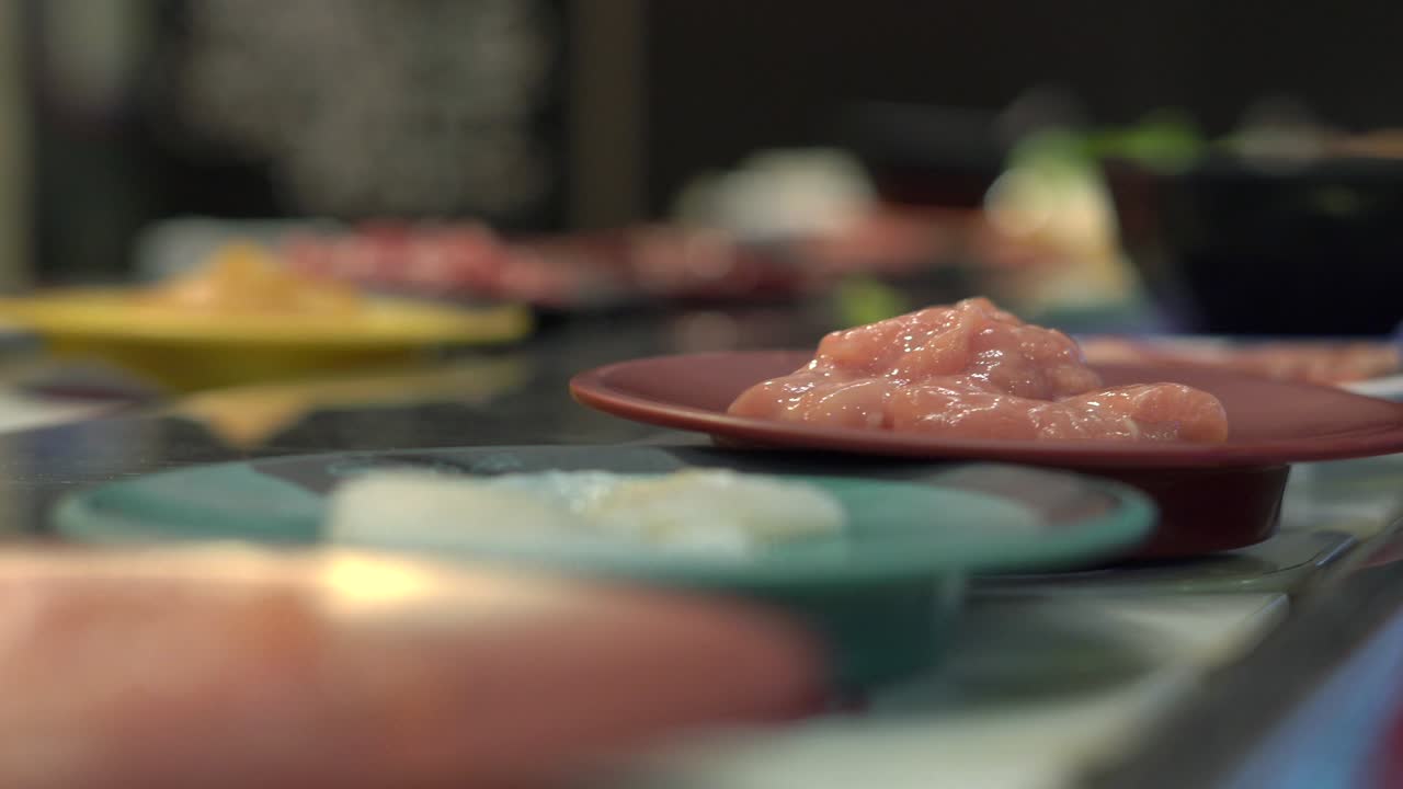 식품 컨베이어: 아시아 스타일의 카페에서 식품이 컨베이어에서 작은 접시로 움직입니다. 음식 비의 개념. 과식의 개념을 비합니다.