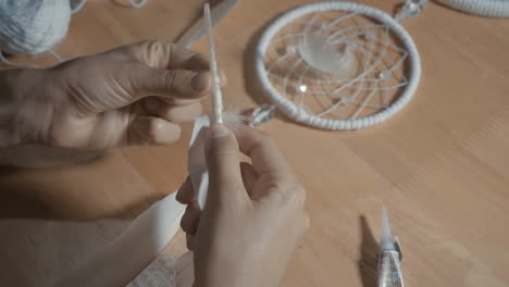 female hands creating dream catcher closeup