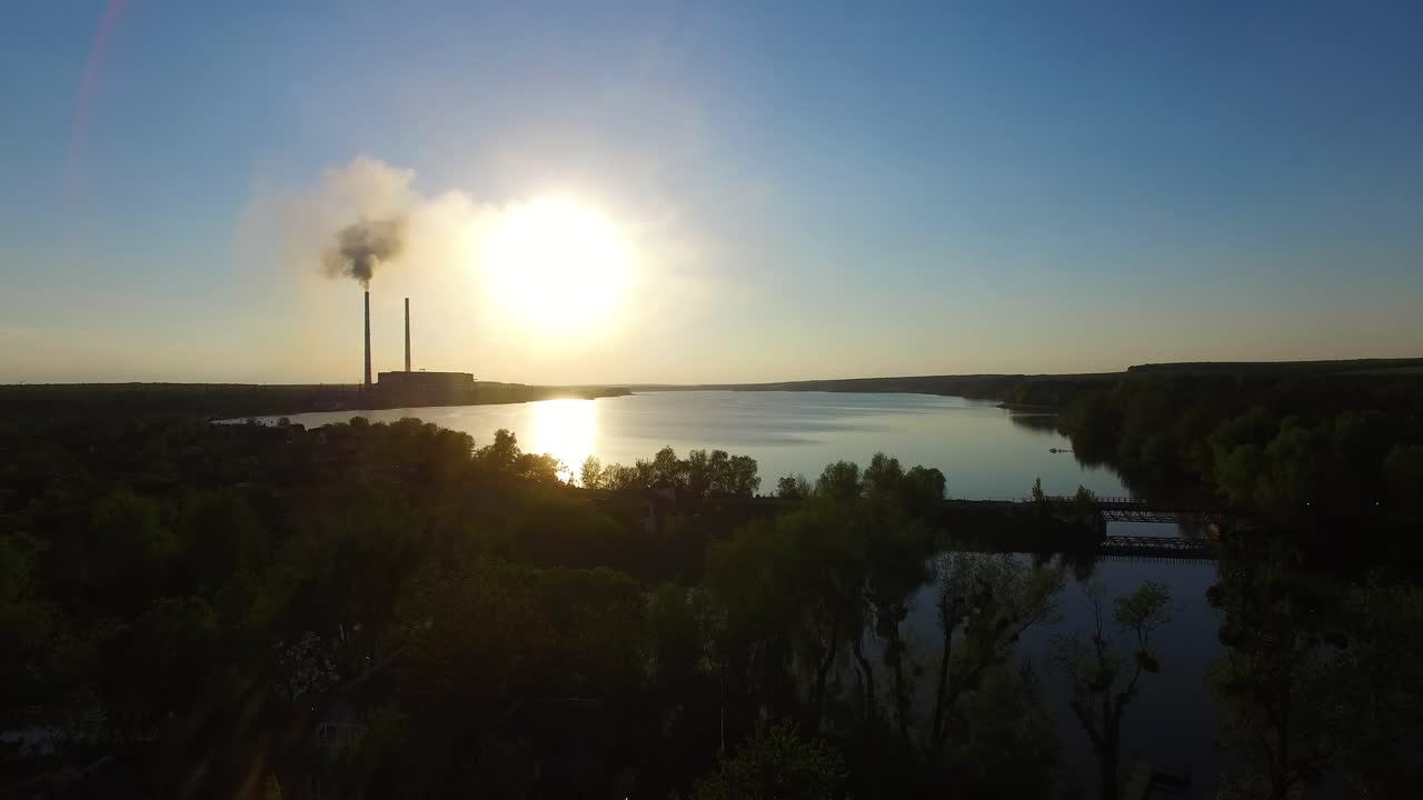 Smoking factory at sunset. Industrial factory smoke from smokestacks over sunset