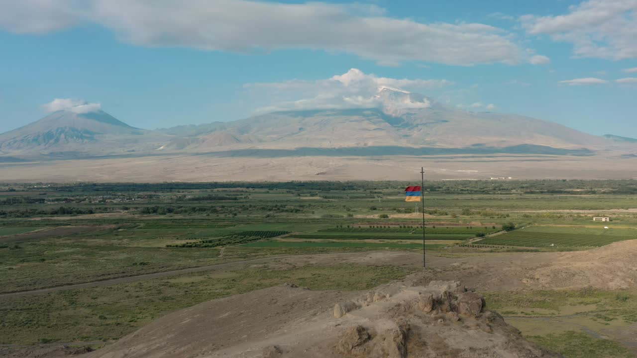 disparo aéreo de avión no tripulado zoom out disparo de bandera ondeando en la colina en armenia