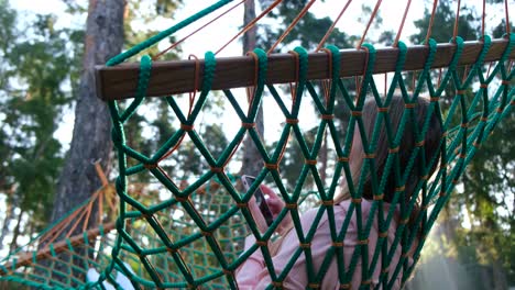 girl playing on a smartphone lying on a hammock during the holidays summer vacation in the pine forest girl playing on a smartphone lying on a hammock during the holidays