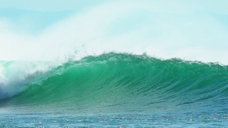 Cinematic slow-motion stunning aqua blue huge wave surf barrel swell wind froth Hossegor Seignosse Biarittz Basque Country European holiday destination WSL ocean tide stunning summer day pan follow
