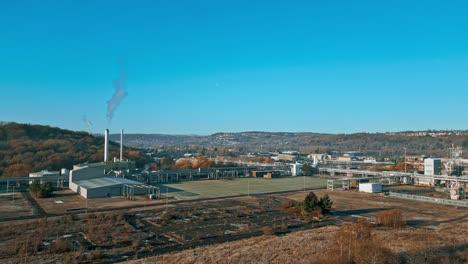 Aerial-footage-moving-towards-a-large-industrial-chemical-plant,-showing-pipelines,-metal-structures,-cooling-towers-and-chemical-storage