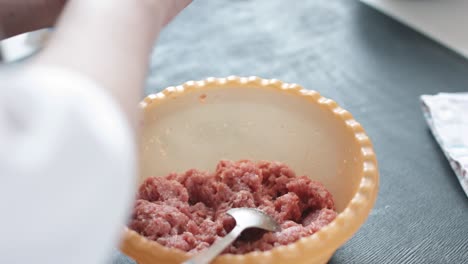 two hands making meat dumplings.