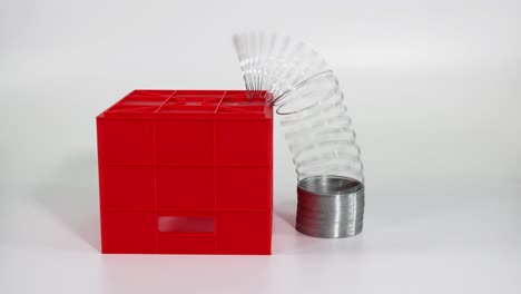 slinky moves around red boxes on white surface