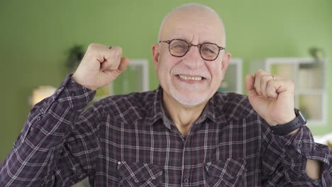 el viejo alegre se alegra en casa mirando a la cámara.