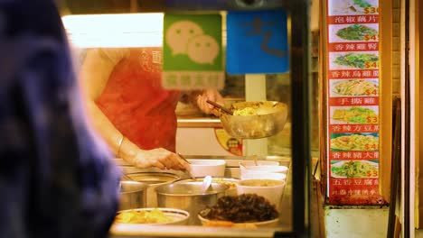 vendor preparing food at a bustling street stall