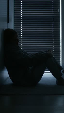 sad woman sitting alone in the corner of a room