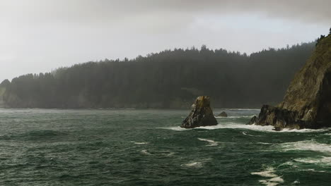 pan right revealing rocky cliffs along oregon coast battered by pacific ocean