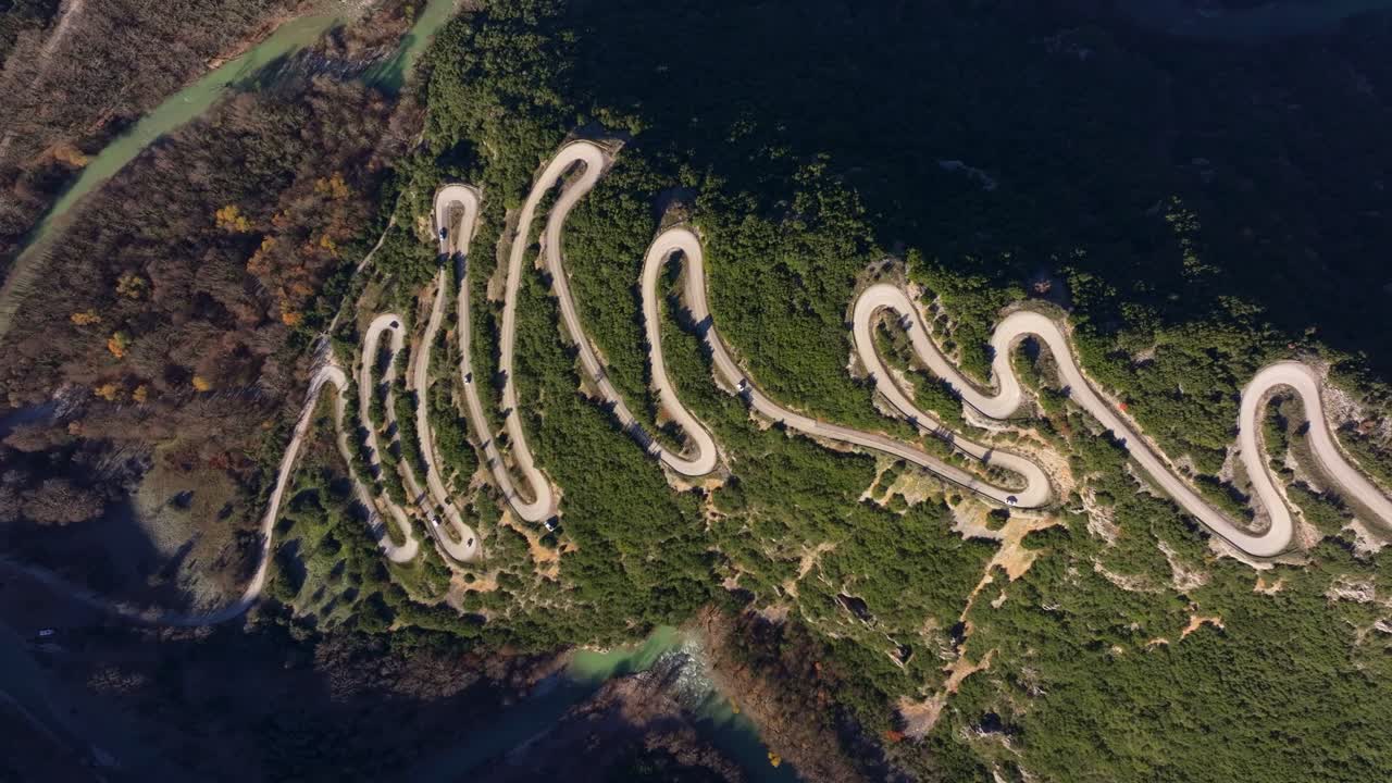 Drone view of winding mountain route wrapped in trees, Papigko